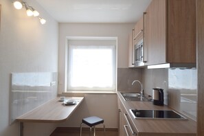 Appartement Affaires | Cuisine privée | Réfrigérateur, micro-ondes, plaque de cuisson, cafetière/bouilloire