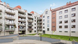 A modern apartment building with multiple balconies, a courtyard, and a brick facade. - Rent a Flat Apartments - Torunska 18 (Gdansk)