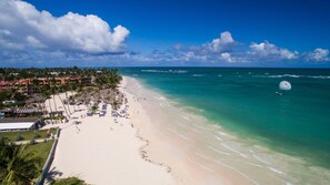 On the beach, white sand, sun-loungers, beach umbrellas