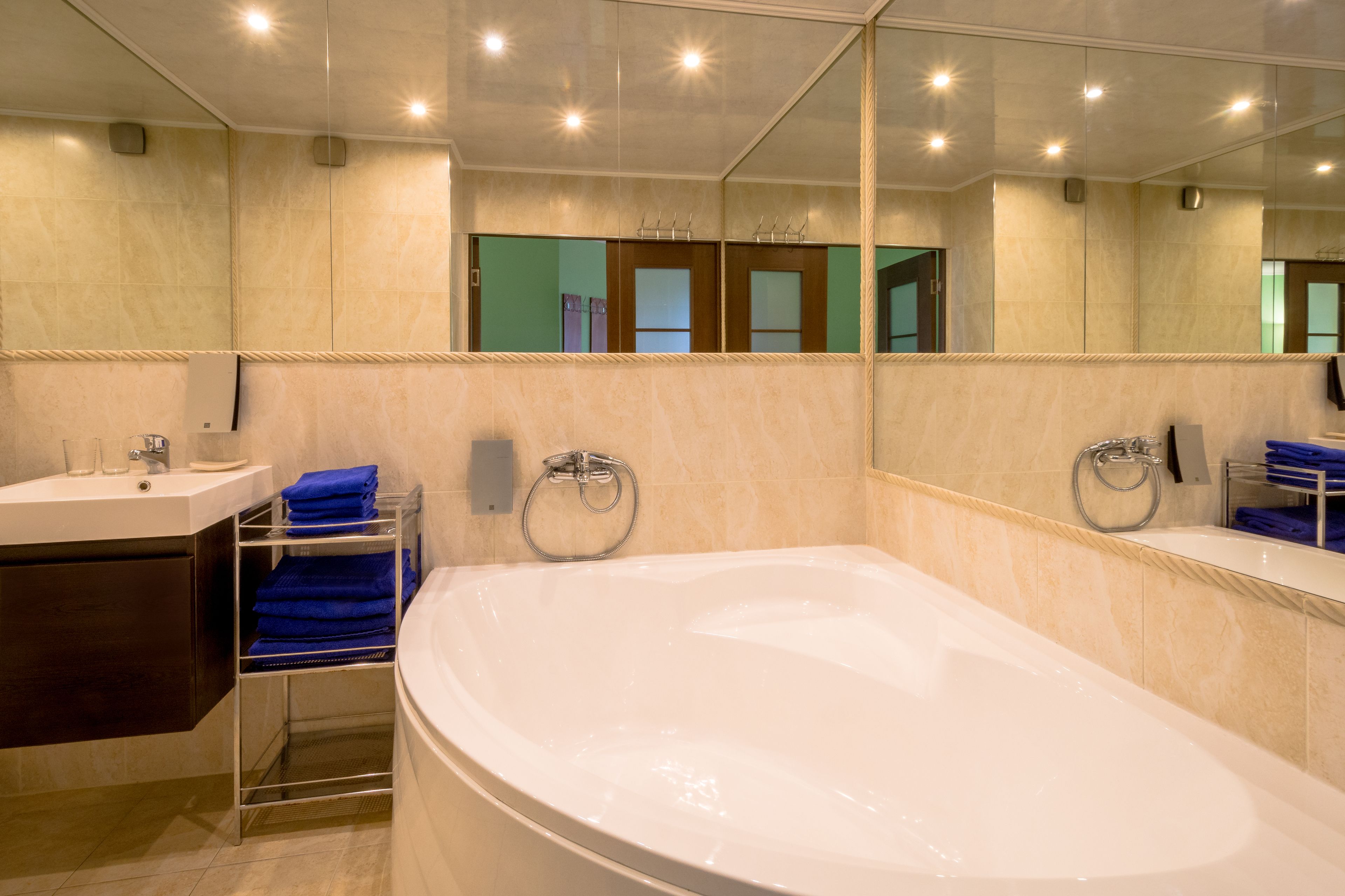 A modern bathroom with a large bathtub, a sink, and a mirror.