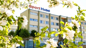 A hotel named Sport Hotel with a modern facade, multiple windows, and a sign above the entrance. - Sport Hotel (Liepaja)