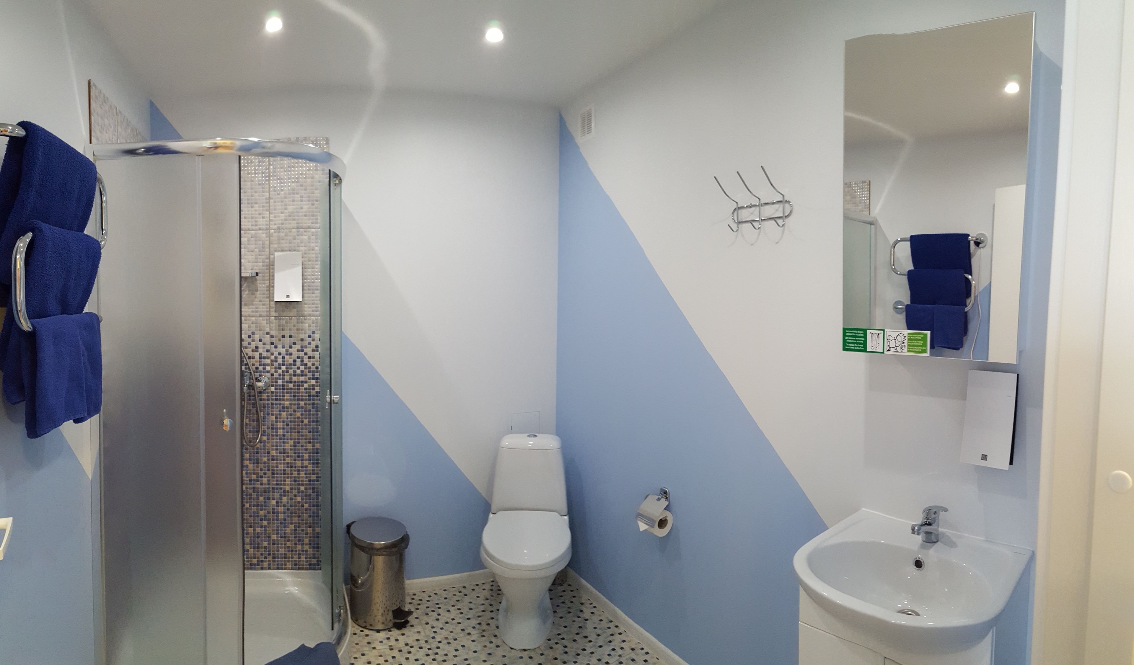Ein Badezimmer mit Dusche, Toilette, Waschbecken und Spiegel.
