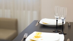A dining table with a plate, a fork, and two wine glasses. - Rent a Flat apartments - Korzenna St. (Gdansk)