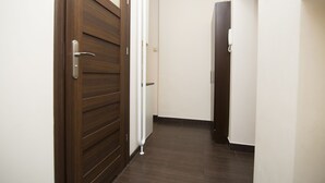 A hallway with wooden doors and white walls. - Rent a Flat apartments - Korzenna St. (Gdansk)