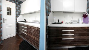 Uma cozinha moderna com armários brancos, bancada preta e painel decorativo.