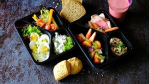 Uma refeição com diversos pratos, incluindo ovos, salada, fruta e pão.