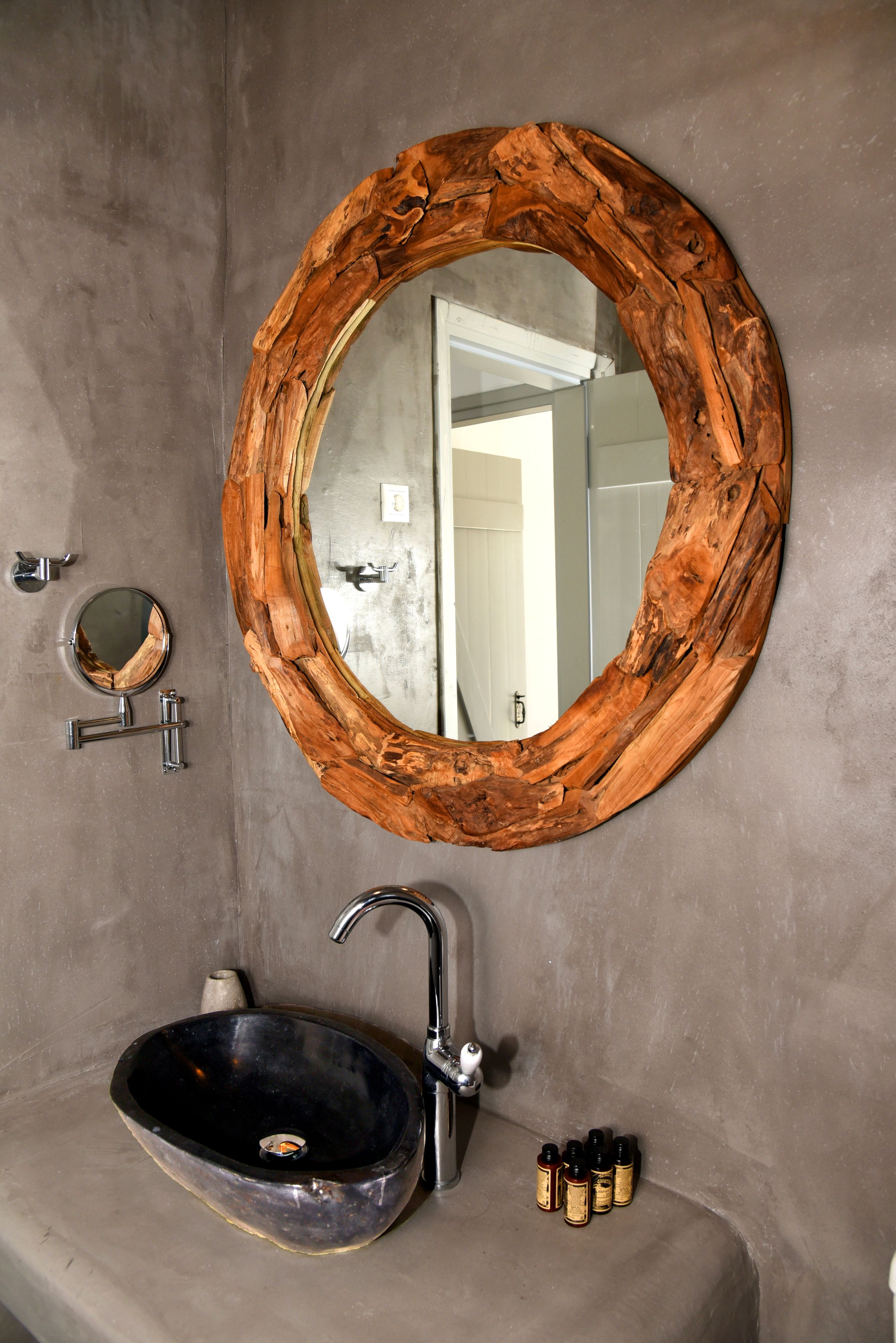 A bathroom with a round mirror, a sink, and a faucet.