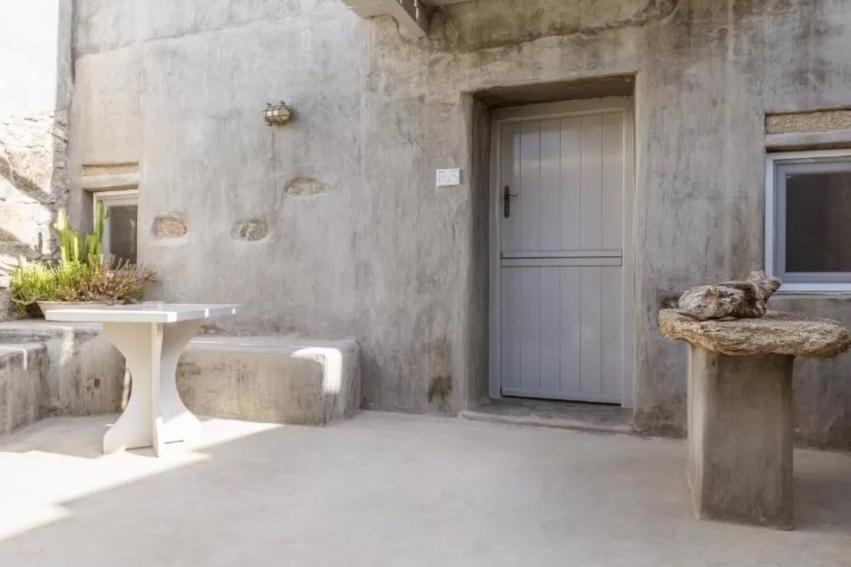 Un bâtiment en béton avec une porte, une petite table et un élément décoratif en pierre.
