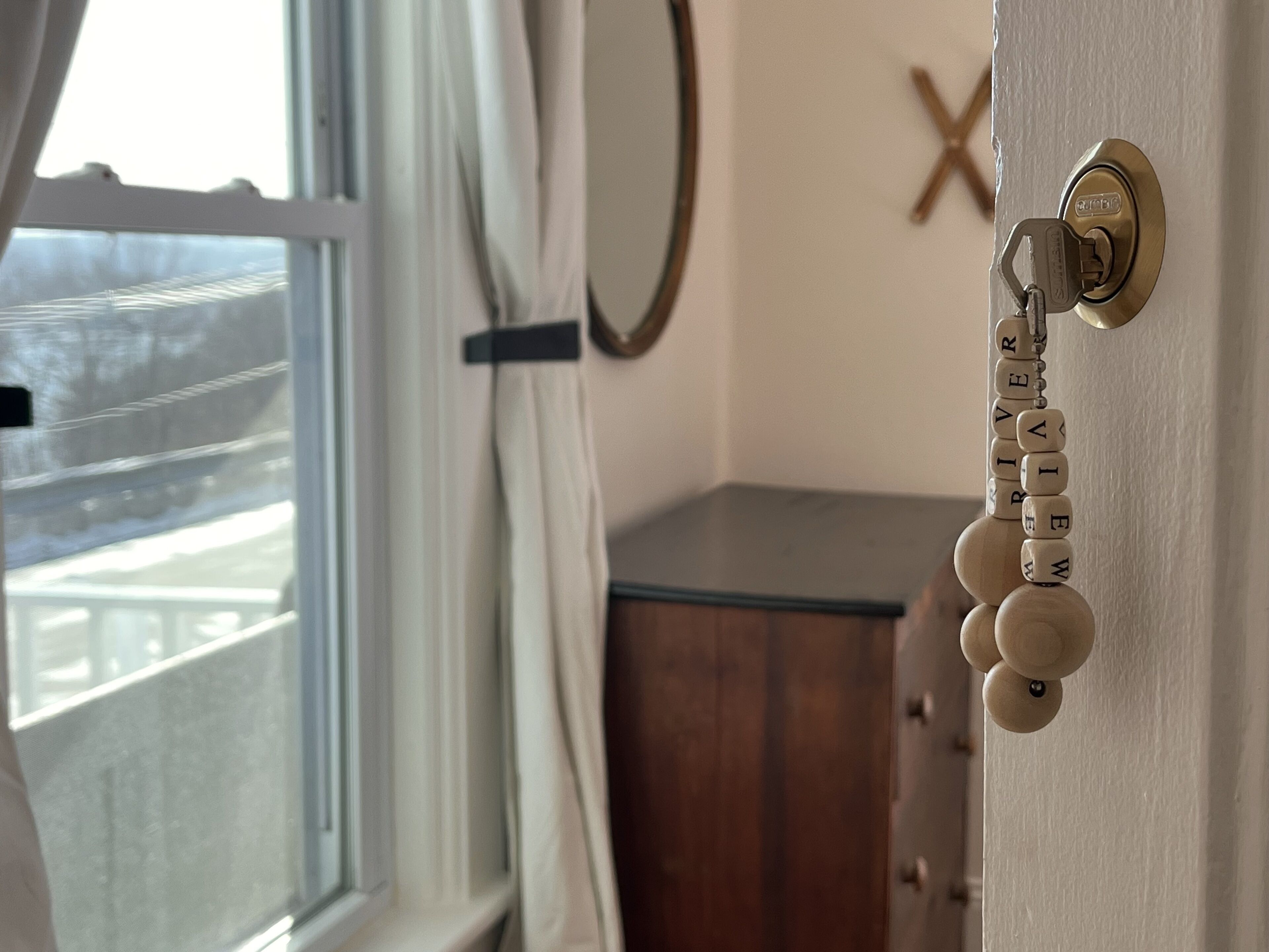 Une porte avec un trou de serrure, un meuble en bois et un miroir accroché au mur.