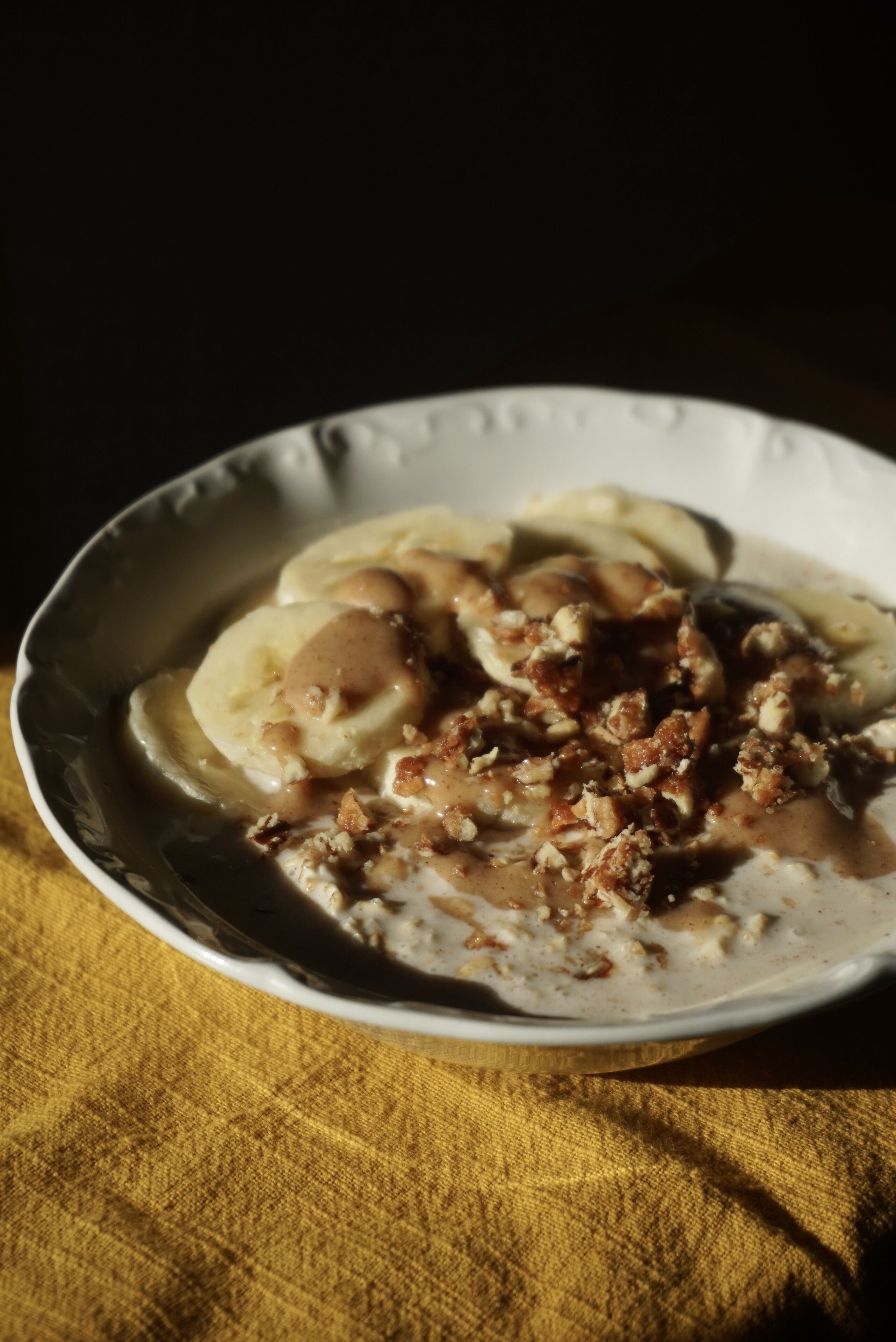 Un bol de nourriture contenant des bananes et des noix, le tout présenté sur une assiette.