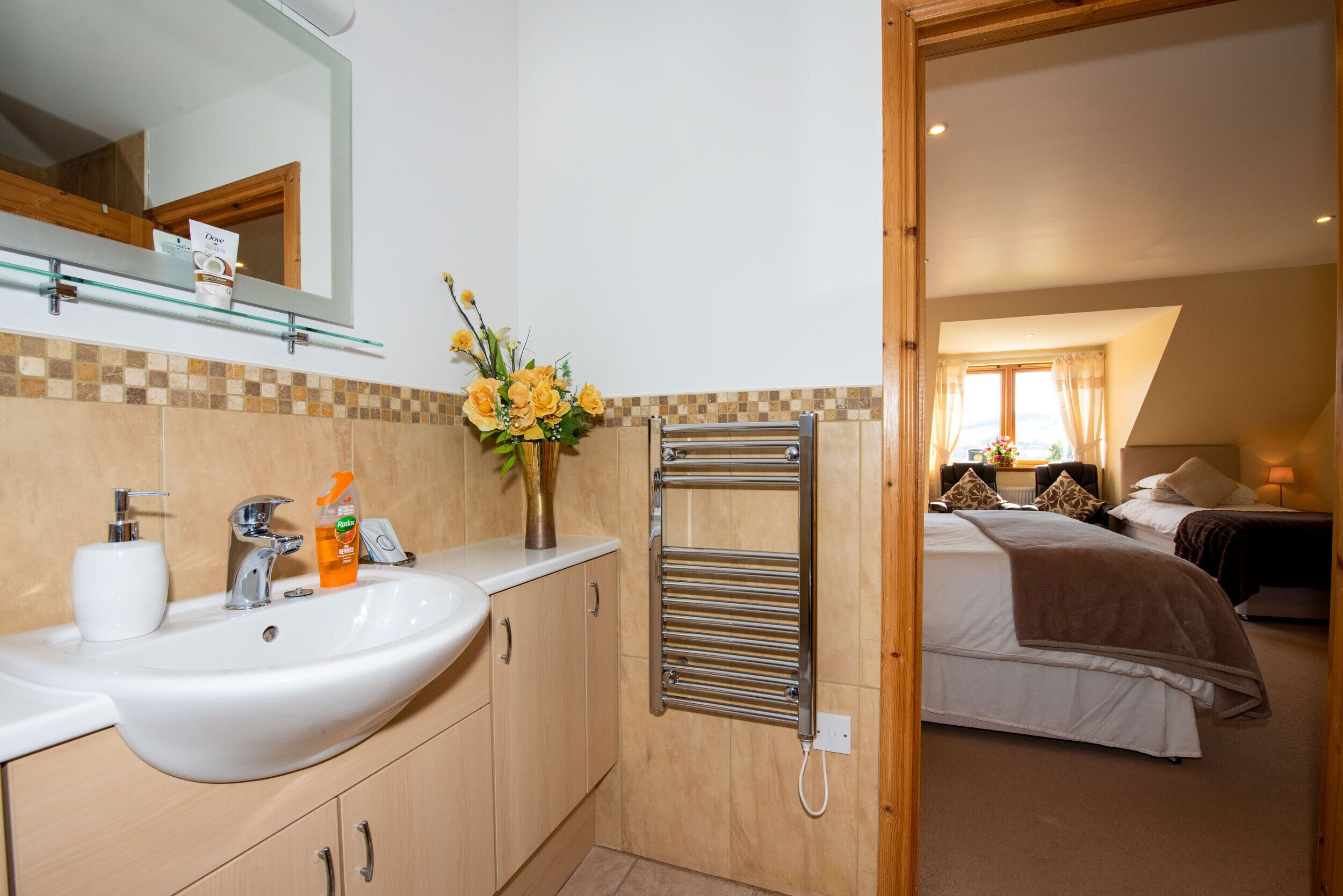 A bathroom with a sink, mirror, and towel rack.