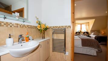 A bathroom with a sink, mirror, and towel rack.