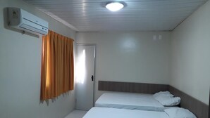 A small, clean room with two single beds, a ceiling fan, and an air conditioning unit. - Hotel Pio (Teresina)