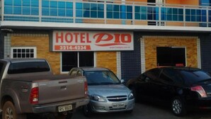 A two-story building with a sign for 'HOTEL PIO' and a contact number. There are three cars parked in front. - Hotel Pio (Teresina)