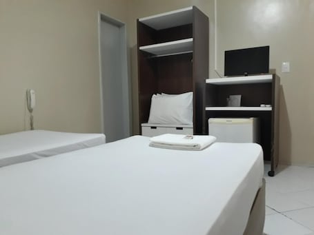 Minibar, escritorio, cortinas blackout y tabla de planchar con plancha