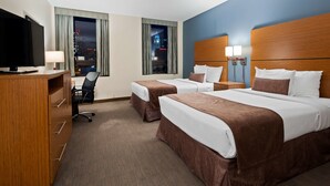 A hotel room with two beds, a desk with a chair, a TV, and a view of a cityscape at night. - Best Western Plus Philadelphia Convention Center Hotel (Philadelphia)