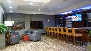 A modern bar area with a TV, seating, and a wooden floor. - Best Western Plus Philadelphia Convention Center Hotel (Philadelphia)