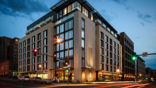 A multi-story hotel with a modern architectural design, featuring large windows and a prominent entrance. - The Maven Hotel at Dairy Block (Denver)