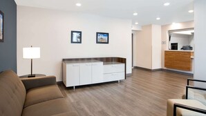 Un hall d’hôtel moderne avec un canapé, un bureau et un comptoir d’accueil.