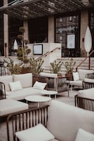 An outdoor seating area with wicker furniture and potted plants.