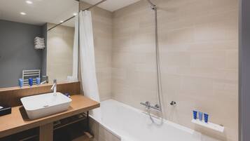 A modern bathroom with a white sink, a bathtub, and a shower.