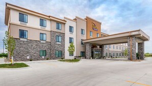 A modern hotel with a stone facade, multiple windows, and a covered entrance.