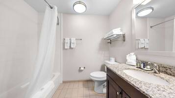 A modern bathroom with a shower, toilet, and sink.