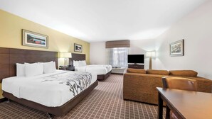 Ett hotellrum med en stor säng, en soffa, en TV och ett skrivbord.