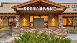 Un restaurante con fachada de piedra, vigas de madera y un letrero sobre la entrada.