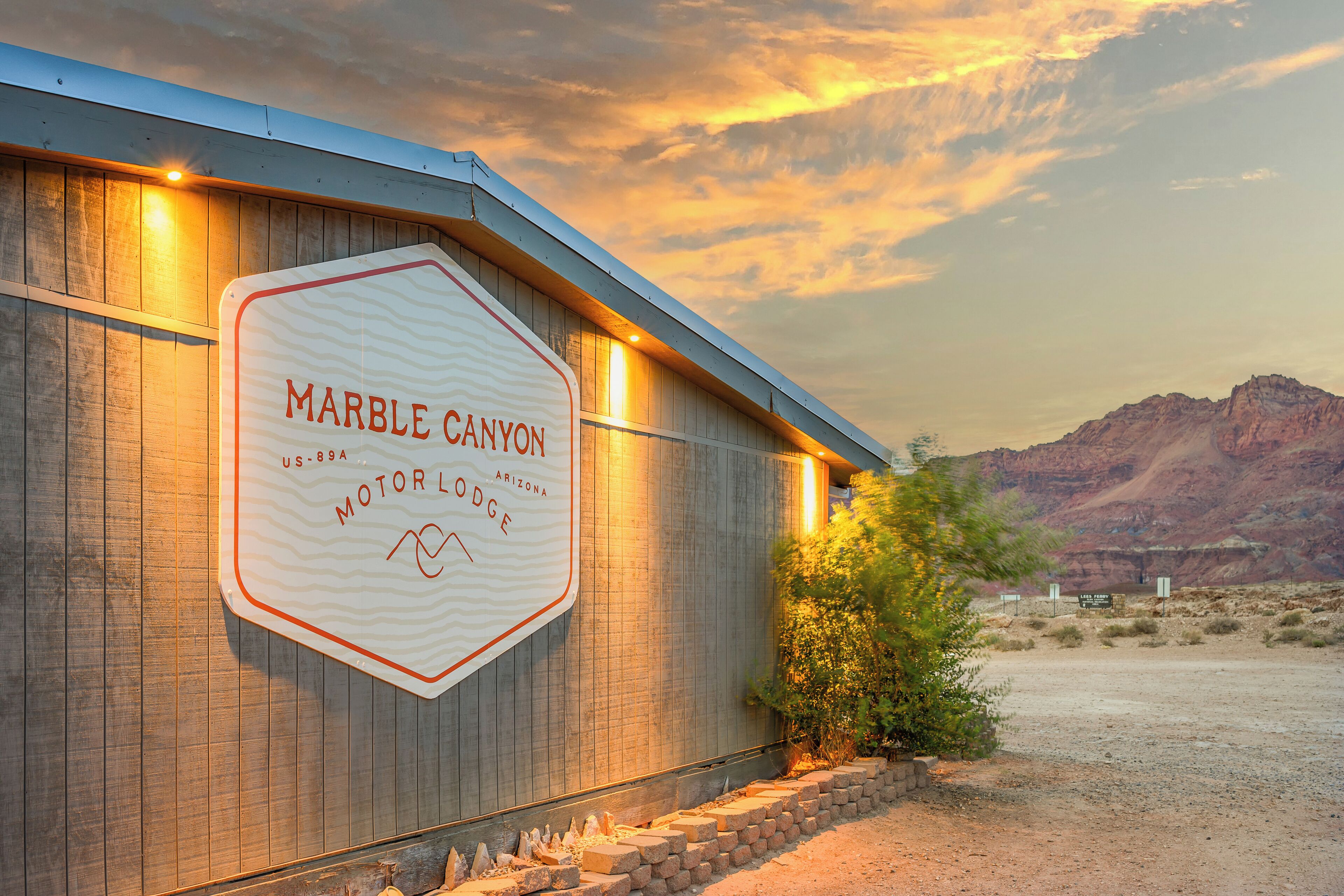 A sign for Marble Canyon Motor Lodge with a mountainous backdrop.