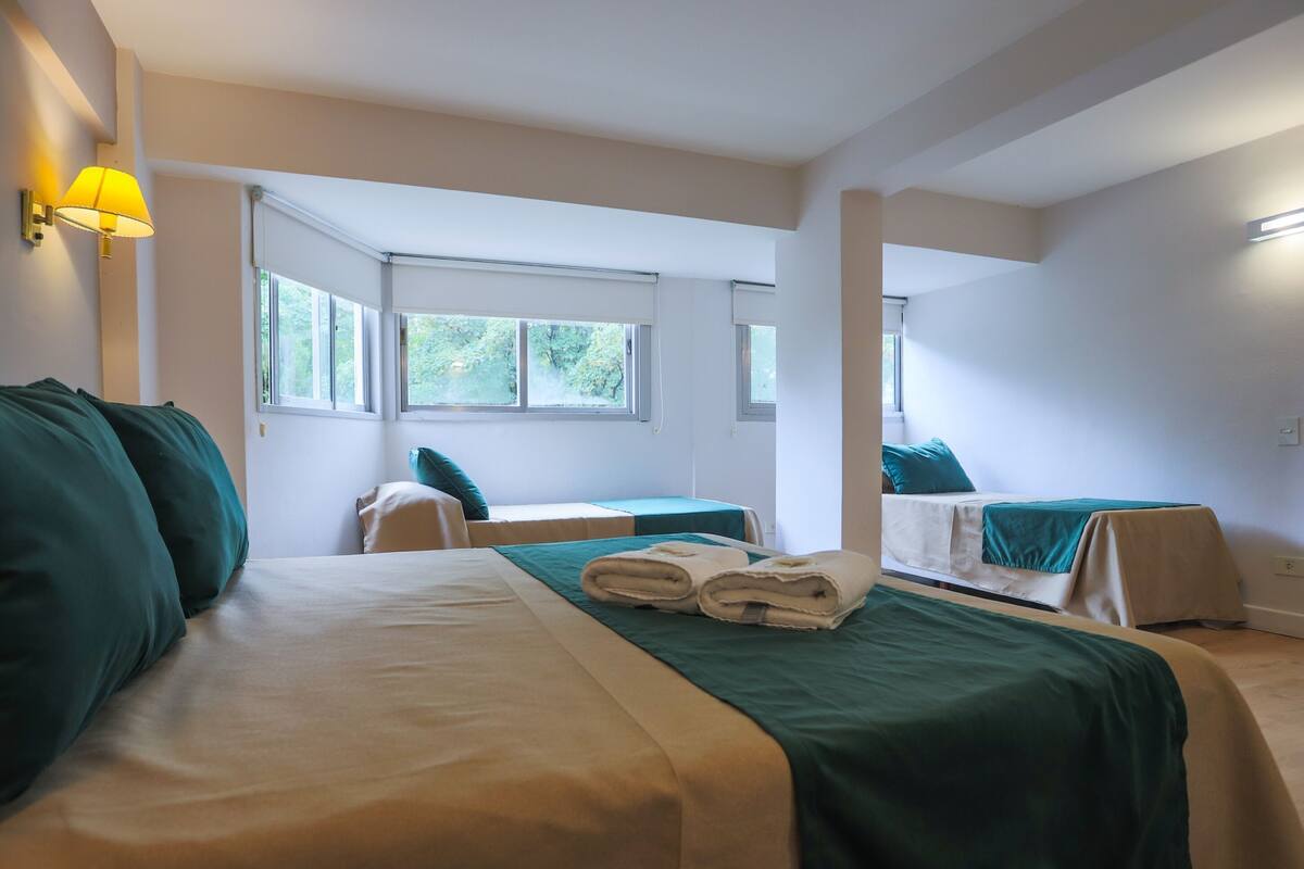 Ein Hotelzimmer mit zwei Betten, einem großen Fenster und einer Lampe.