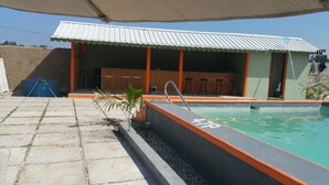 A swimming pool with a number 4179, a covered seating area, and a small bar. - Kiskeya Guest House (Léogâne)