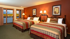 A hotel room with two beds, a balcony, and a view of the outdoors. - The Pointe Hotel and Suites (Minocqua)