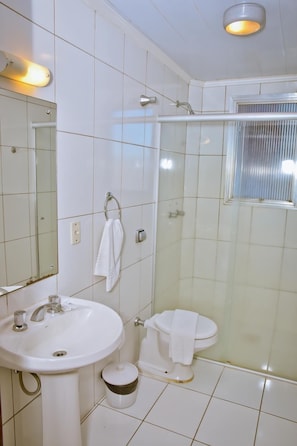 A bathroom with a sink, toilet, and shower. - Hotel Estoril (Pelotas)
