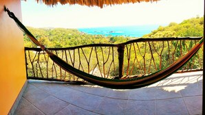 A hammock on a balcony with a view of a coastal landscape. - Cabañas Telayú (Santa María Tonameca)