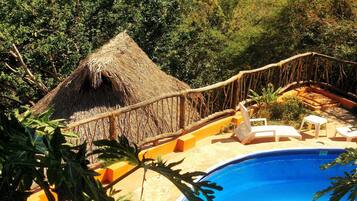 Alberca al aire libre y camastros