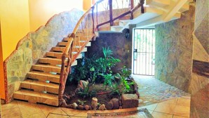 A spiral staircase with wooden steps and a stone wall. - Cabañas Telayú (Santa María Tonameca)