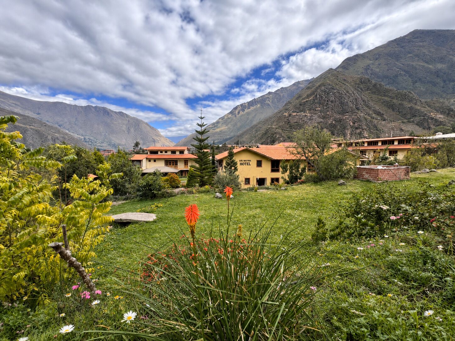 Un hotel con varias construcciones, rodeado de montañas y vegetación exuberante.