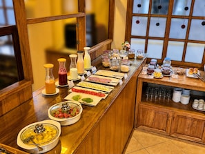 A buffet setup with various food items and condiments. - Sol Natura Hotel (Ollantaytambo)