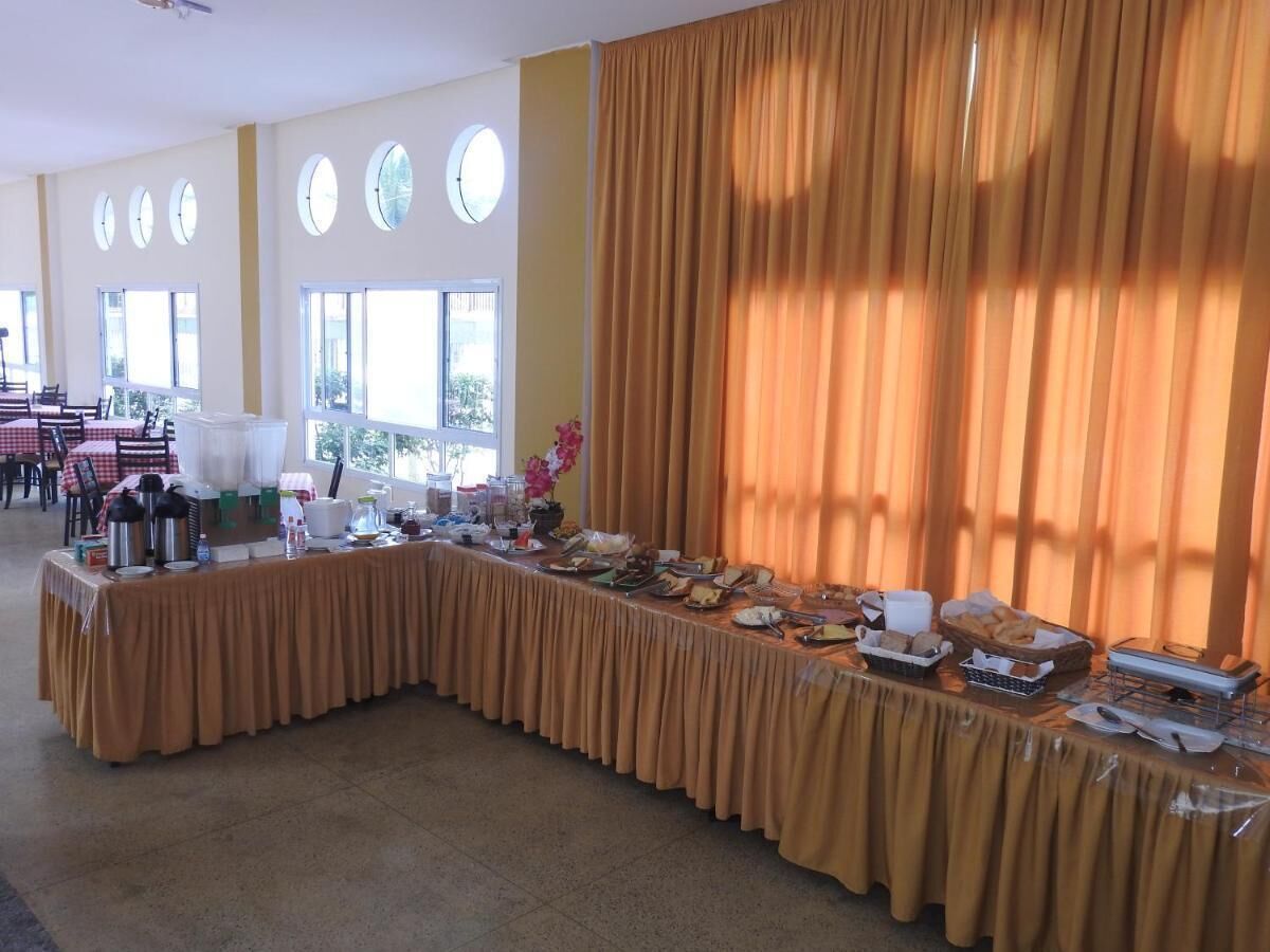 Montaje de bufé con una larga mesa, ventanas redondas y cortinas.