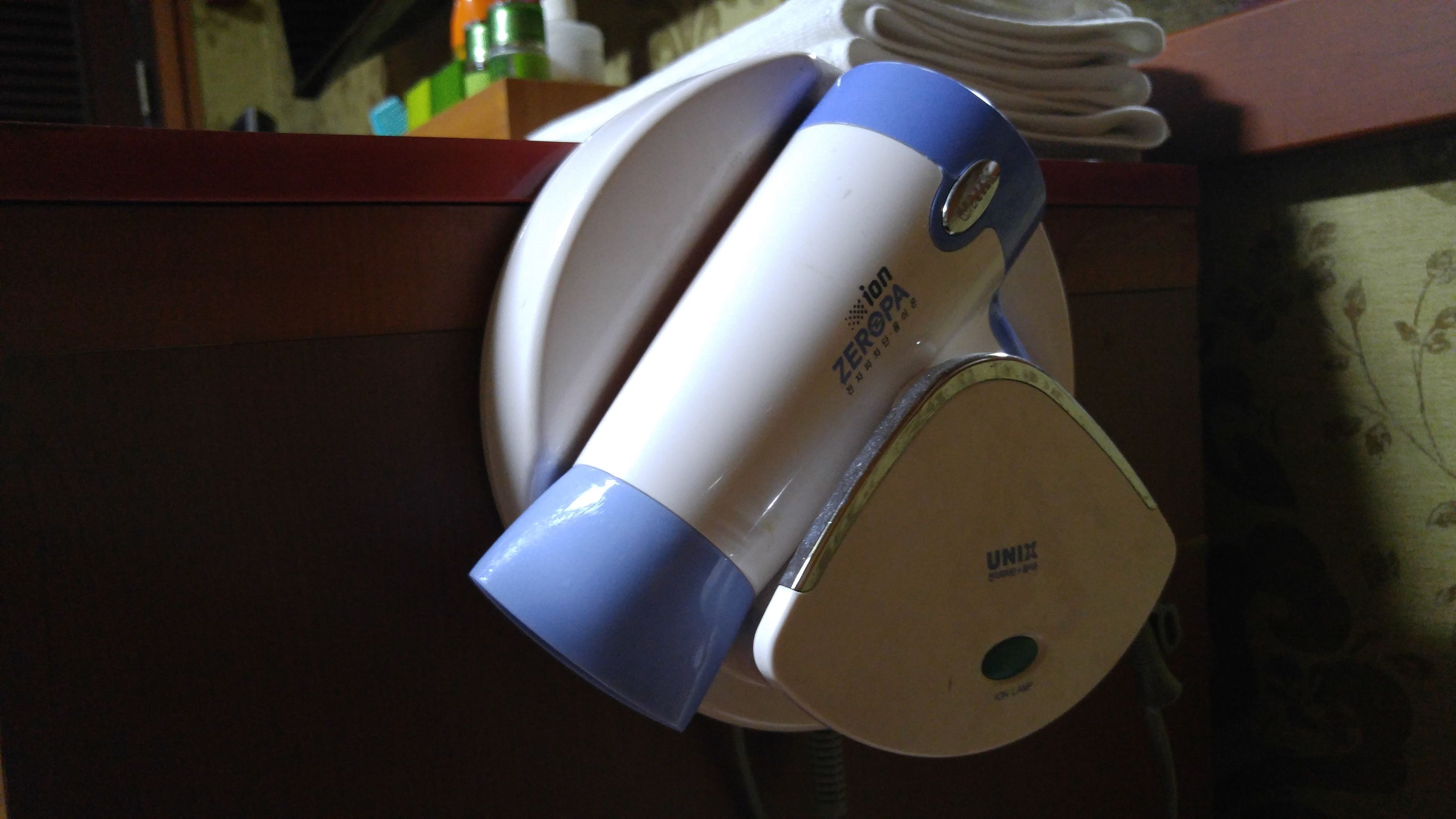 A hairdryer and a curling iron on a counter.