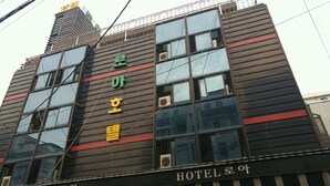 Un edificio de hotel con varios pisos, ventanas grandes y un cartel que indica que es un hotel.