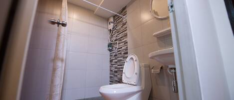 Une salle de bain moderne équipée de toilettes, d’une douche et d’un lavabo.