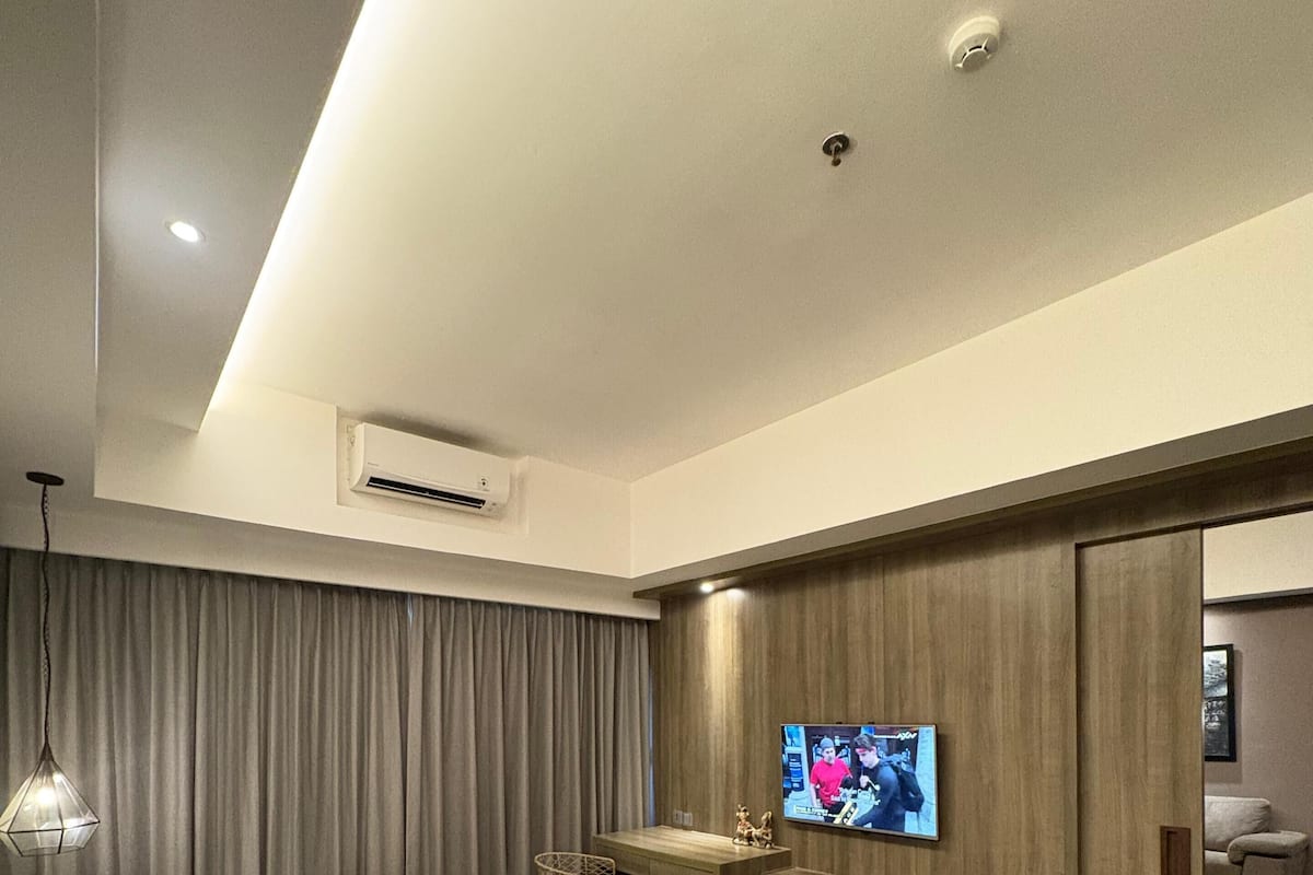 A modern hotel room with a large bed, a desk, a television, and a bathroom.
