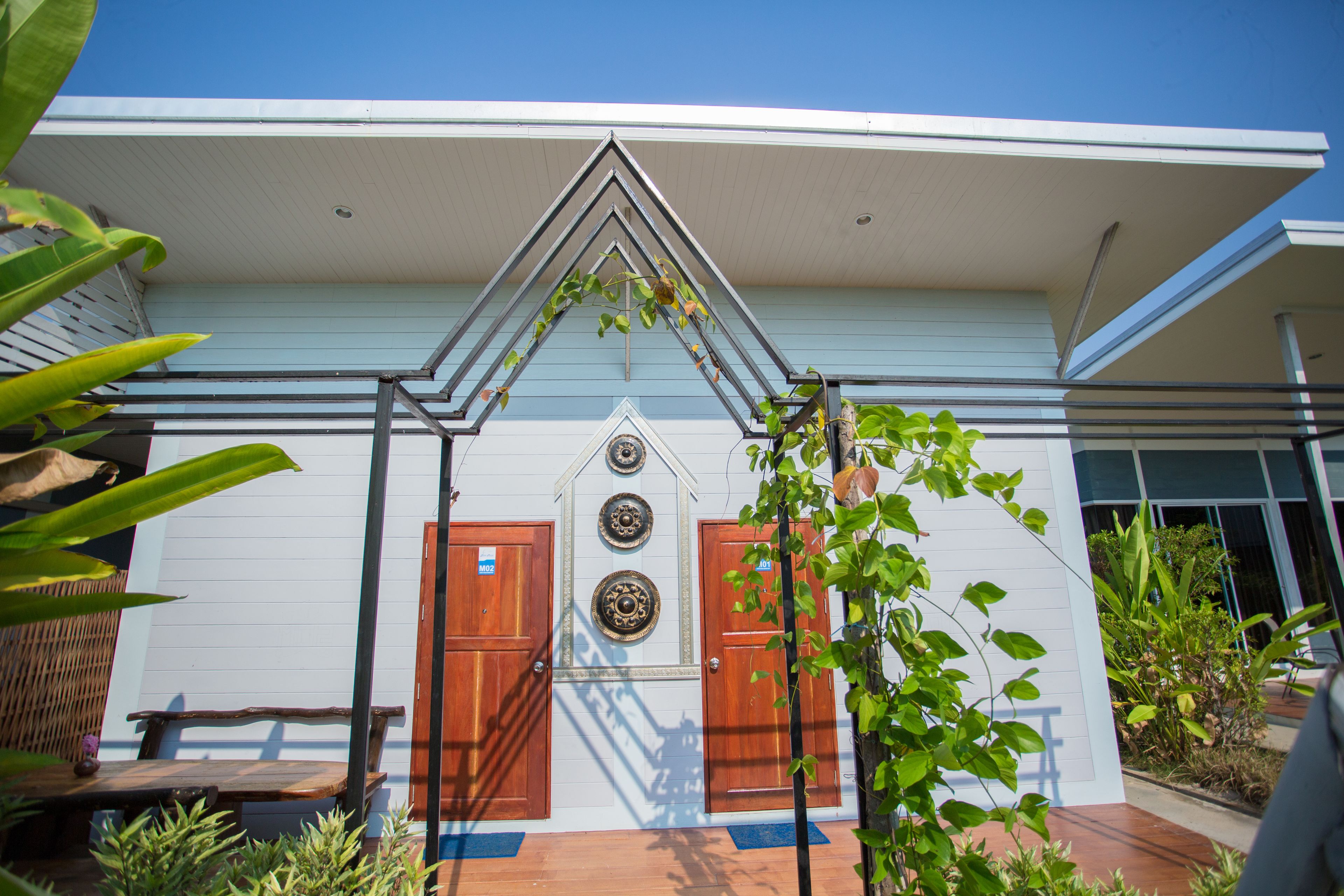A building with a triangular roof, two wooden doors, and a small porch area.
