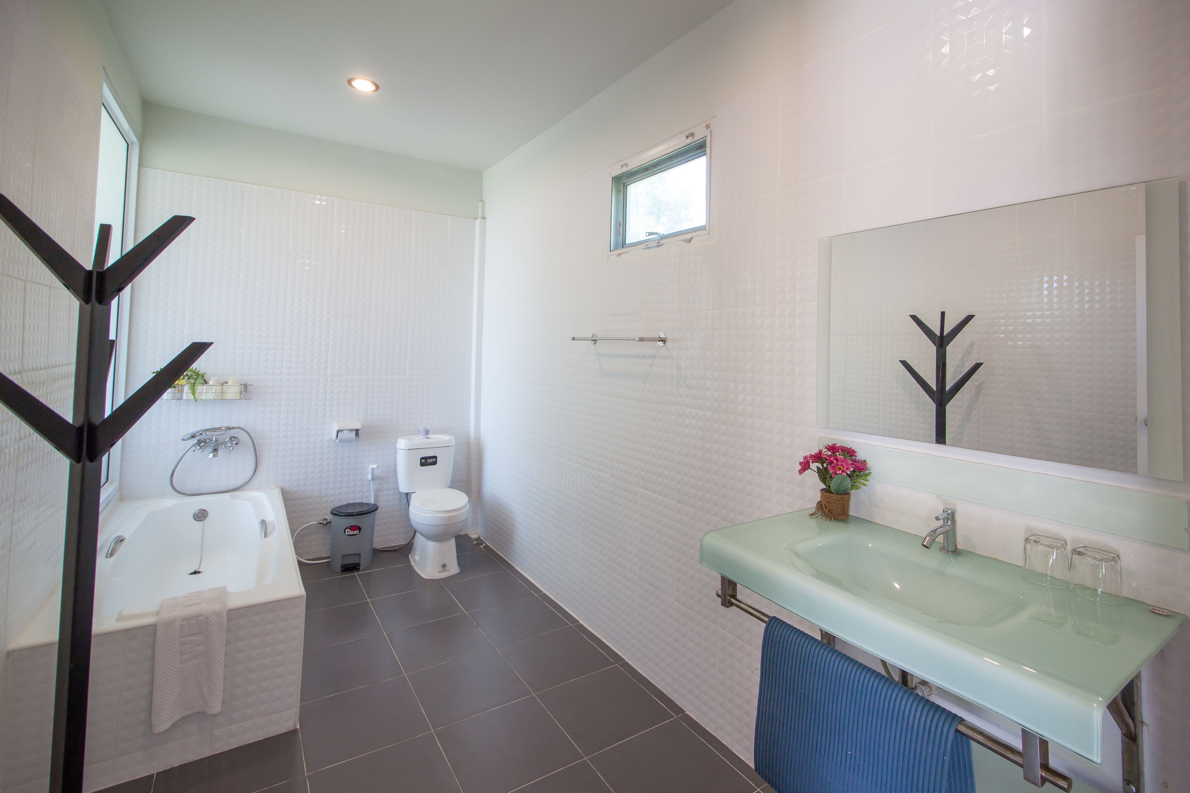 A modern bathroom with a bathtub, toilet, and sink.