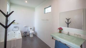A modern bathroom with a bathtub, toilet, and sink.