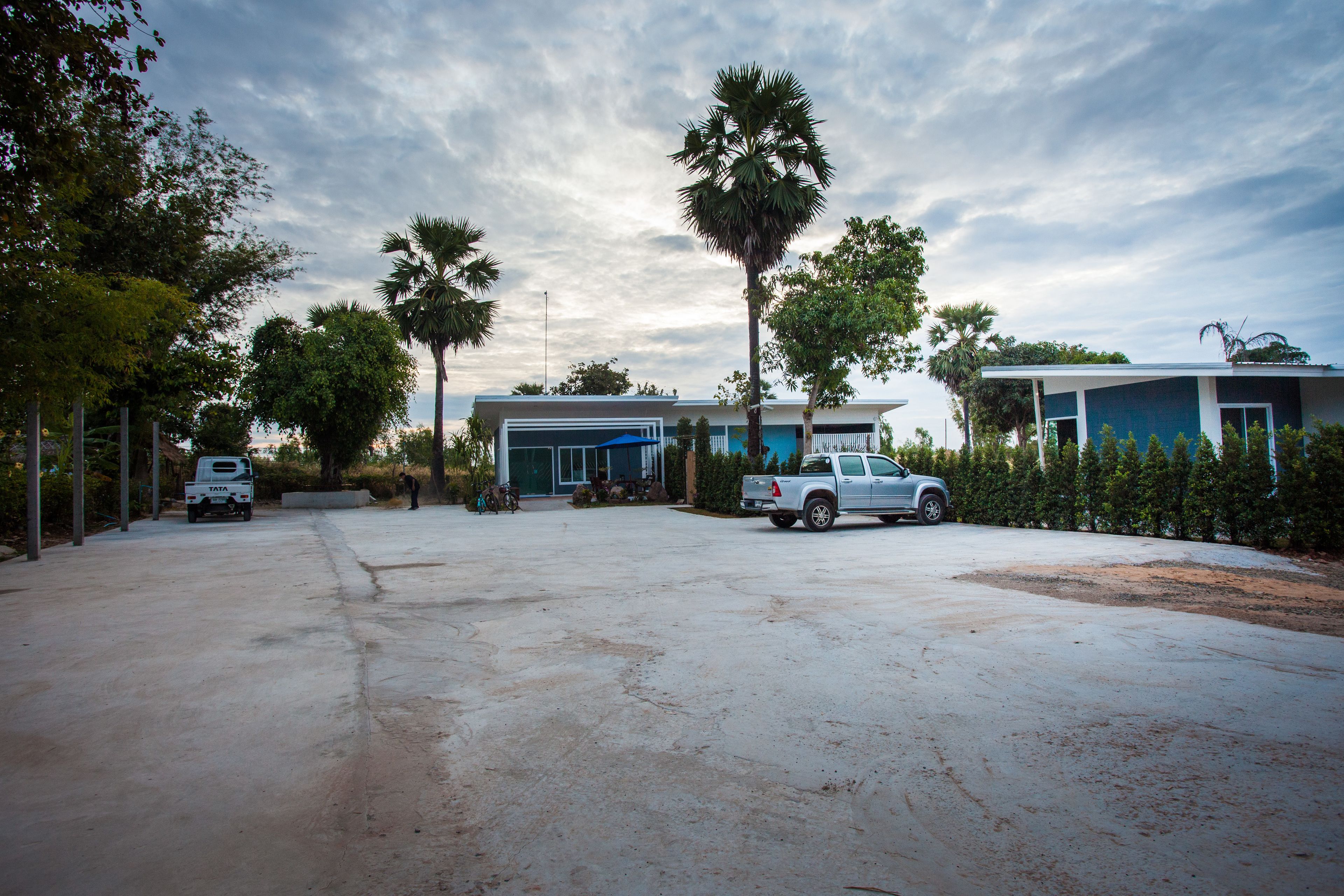 A residential area with a garage, parked vehicles, and a house with a blue exterior.