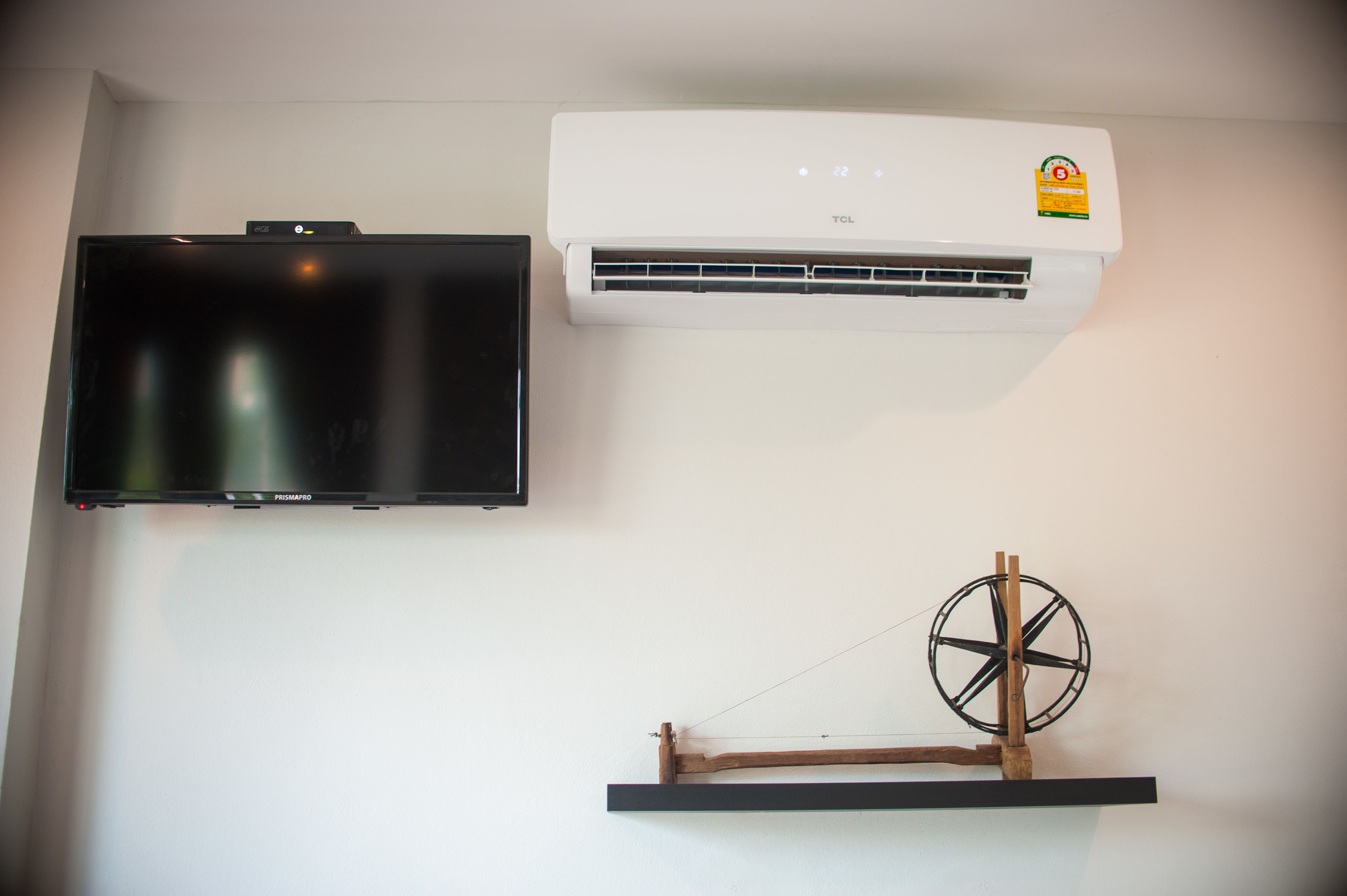 A wall-mounted TV and air conditioner.