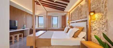 A bedroom with a wooden canopy bed, a TV, and a stone wall.